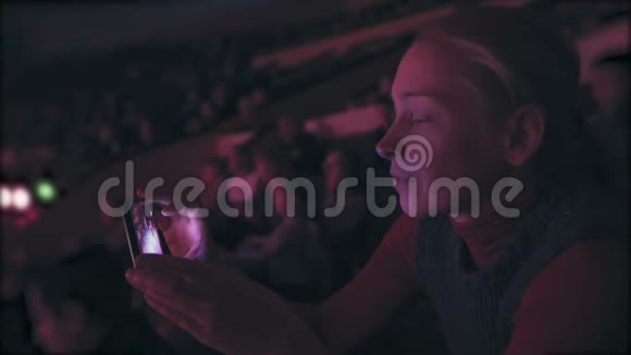 一位坐在马戏团礼堂的女士在竞技场上用智能手机拍照视频的预览图