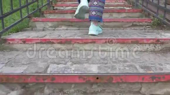 穿着浅绿色运动鞋女人的腿爬楼梯视频的预览图