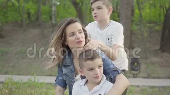 一位可爱的年轻母亲和年幼可爱的孩子在公园里休息的肖像户外娱乐活动视频的预览图