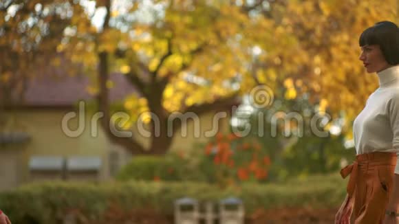 金发和黑发女孩面对面秋天公园的两个女孩秋天女孩的户外肖像秋姑娘视频的预览图