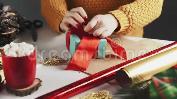无法辨认的女人不裹圣诞礼物在桌子上与圣诞节装饰视频的预览图