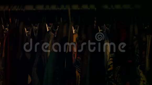 许多五颜六色的女性衣服挂在衣柜里黑暗然后小衣柜灯打开视频的预览图