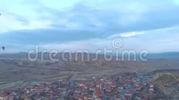 土耳其卡帕多西亚日出时天空晴朗天空中有许多热气球的空中山谷景观视频的预览图