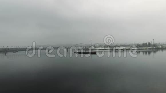 大孤独的老铁驳岸漂在河上在工业城市的河流上苏格兰人在雾中航行空中无人机的视野视频的预览图