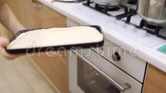 一个女人把烤棒和馅饼放在烤箱里视频的预览图