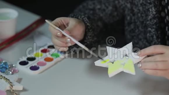 一位年轻女子用水彩画星星为圣诞节做家庭装饰品视频的预览图