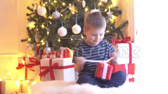 可爱的小男孩解开圣诞礼物孩子在家开新年礼物视频的预览图