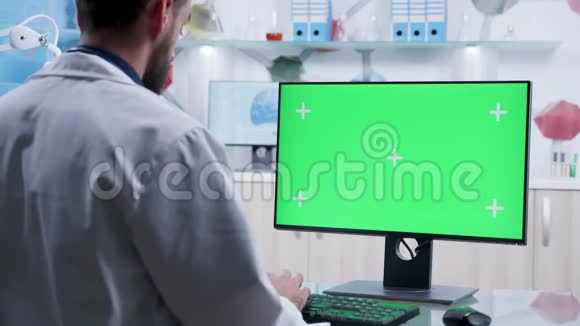 放大医生在绿色屏幕电脑上打字的镜头视频的预览图