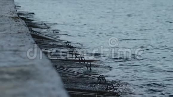 傍晚时分冰冷的暗海波缓慢地拍打着古老的水泥防波堤视频的预览图