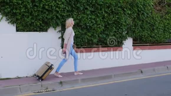 带着旅行袋的女人来到酒店门口抵达酒店或度假视频的预览图