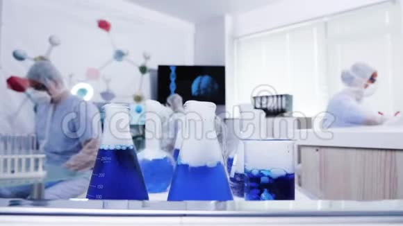 在现代科学实验室的手推车上吸烟的蓝色液体视频的预览图