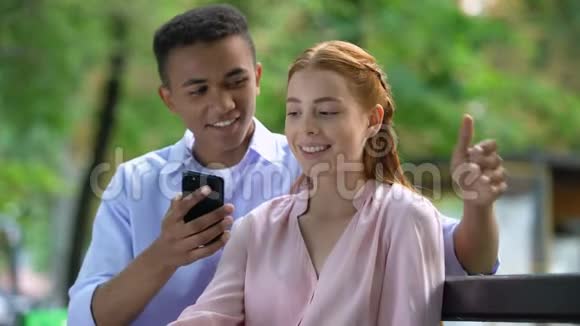 青少年男孩显示智能手机屏幕快乐女朋友为周年纪念惊喜视频的预览图