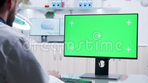 在绿色屏幕电脑上工作的科学家的肩膀上视频的预览图