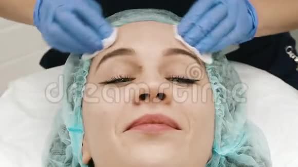 美容师的特写镜头用纸餐巾客户的脸视频的预览图
