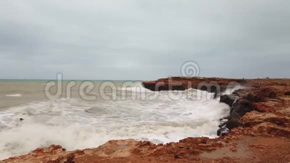 海浪拍打着石头暴风海海浪拍打着天空下的岩石视频的预览图