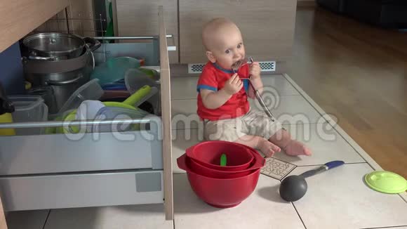 小男孩在厨房地板上玩餐具一个人在家视频的预览图