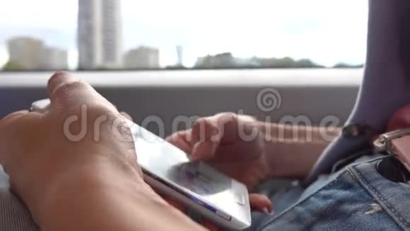 女孩在火车上用她的智能手机点击设备触摸屏4K特写视频视频的预览图
