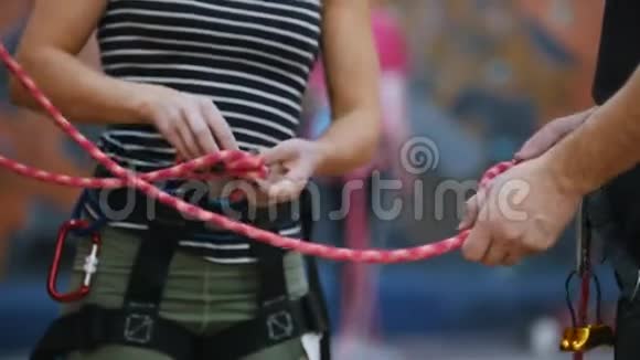 极限运动一个女人系好保护绳以便在教练指示下攀爬视频的预览图