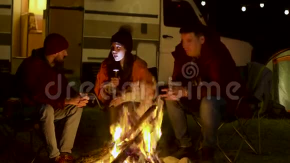 一个女孩在篝火旁给朋友们讲一个可怕的故事视频的预览图