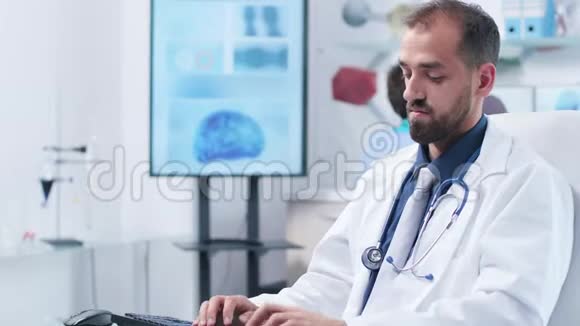 在现代研究中心一位医生正在电脑键盘上打字视频的预览图