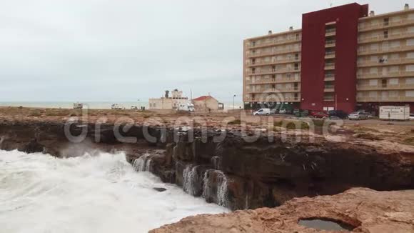 海浪溅起的水溅在石头上视频的预览图