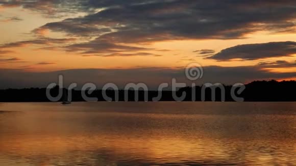 日落时分小游艇在湖中游来游去美丽的云彩和日落景观视频的预览图