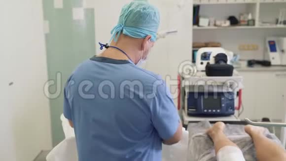 无菌手套医生在静脉曲张术前消毒病人腿部及准备医疗工具视频的预览图