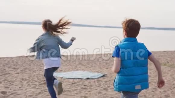 两个孩子在沙滩上海边跑步视频的预览图