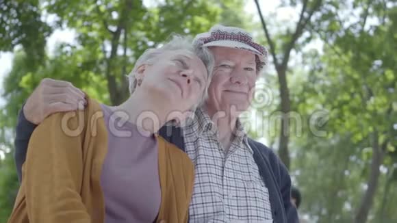 可爱的成熟情侣坐在公园的长凳上相爱的肖像可爱的女人和老人在一起投标视频的预览图
