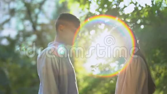 两个十几岁的恋人在阳光公园拥抱第一次恋爱浪漫的感觉视频的预览图