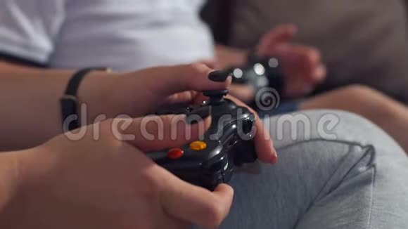 特写一个女孩和一个孩子玩电子游戏手里拿着操纵杆视频的预览图