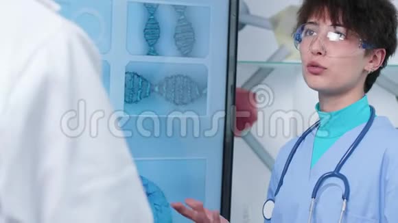 医学研究机构护士手持镜头用DNA样本看大电视视频的预览图