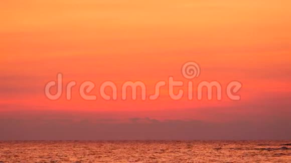 4K美丽的黄昏天空在热带海滩的海上日落后有深橙色的颜色视频的预览图