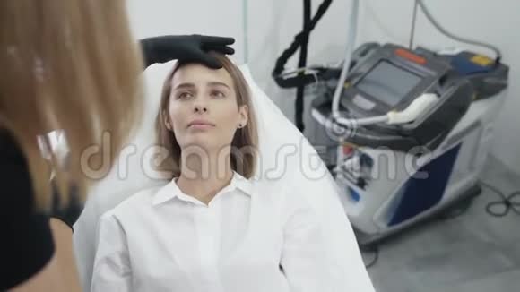 慢动作美容师在手套触摸女孩的脸检查区域的治疗和医疗程序稳定射击视频的预览图
