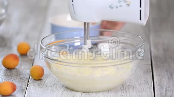 那个女人在面团里加了鸡蛋一步一步的女人在厨房里做杏糕系列视频的预览图