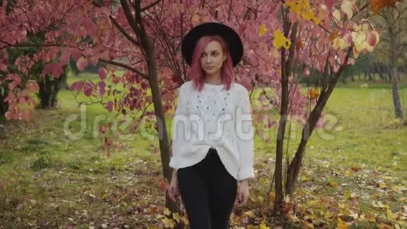 带着粉红色头发的时尚女孩在镜头前散步在公园里矫正头发视频的预览图