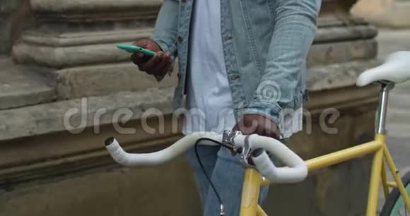 黄牌现代自行车特写镜头白牌和美国黑人男子的手在老城街推它视频的预览图