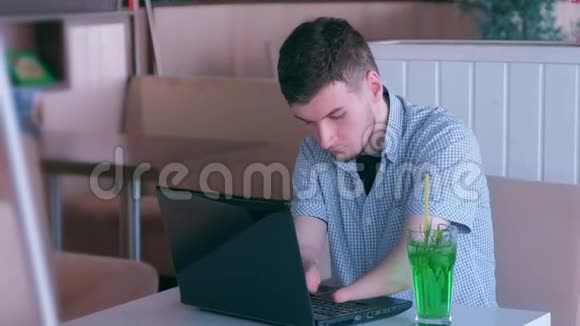 残疾人自由职业者在笔记本电脑和鸡尾酒的咖啡馆工作视频的预览图