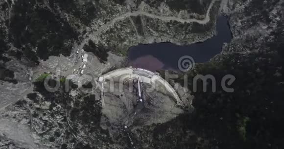 空中射击在一条河前面靠近一条蜿蜒的道路在黑暗的树林里视频的预览图