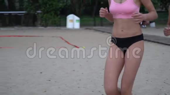 两个穿着比基尼的女人在海滩上奔跑互相嬉戏视频的预览图