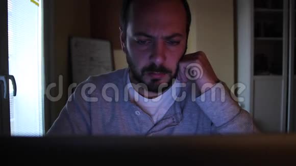 一个在书房的网上学习搜索东西的人他在键盘上写东西看上去很累视频的预览图