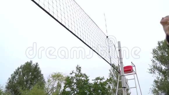 低角度的排球网和一个年轻女子击球视频的预览图