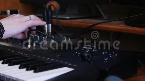 音响制作人工程师在家庭音乐录音室的混合板和音响板上推和转动旋钮和按钮视频的预览图