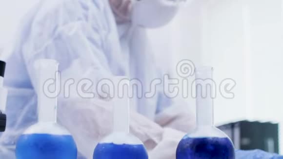 一位女科学家在实验室里拿着一种蓝色的试剂视频的预览图