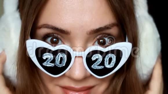 特写一个戴太阳镜的女人的肖像数字2020新年圣诞节女孩微笑着看着镜头视频的预览图