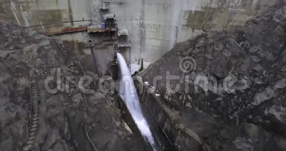 无人机拍摄了一座大坝在有道路和楼梯的山上喷射出一股水流视频的预览图