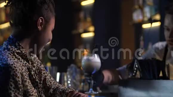 在酒吧喝酒的孤独漂亮女人的侧景视频的预览图