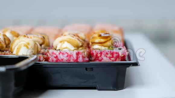 送货食品概念女人从塑料盒里吃寿司卷关门视频的预览图
