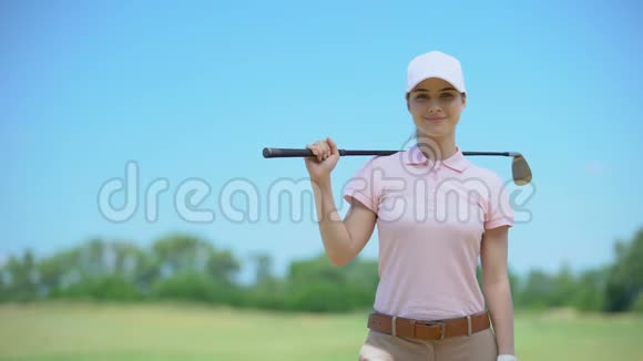 漂亮的女高尔夫球手带着球杆在镜头上微笑最喜欢的爱好课程视频的预览图