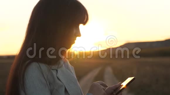 女农民在阳光下用平板电脑在地里干活女孩的手在智能手机屏幕上打印手机信息视频的预览图